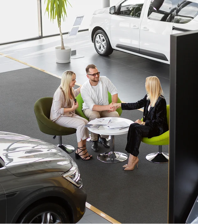 As pessoas apertam as mãos no concessionário automóvel.