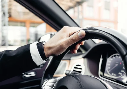 Na fotografia, vê-se um homem sentado ao volante de um automóvel.