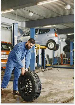 Na fotografia aparece um homem a trabalhar numa oficina ou num centro automóvel.
